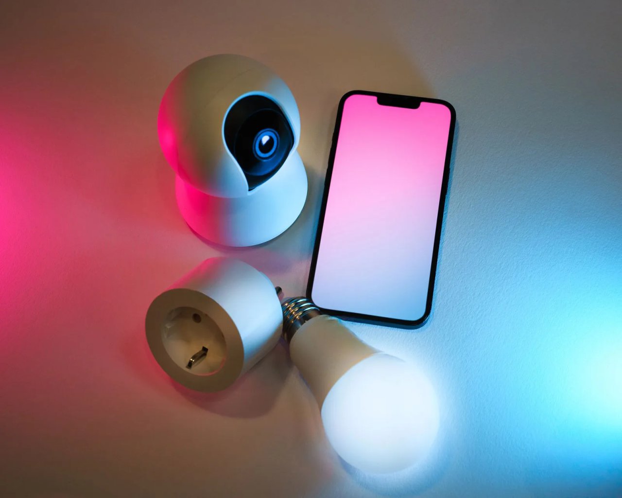 Colourful smart bulb next to a phone with the control app