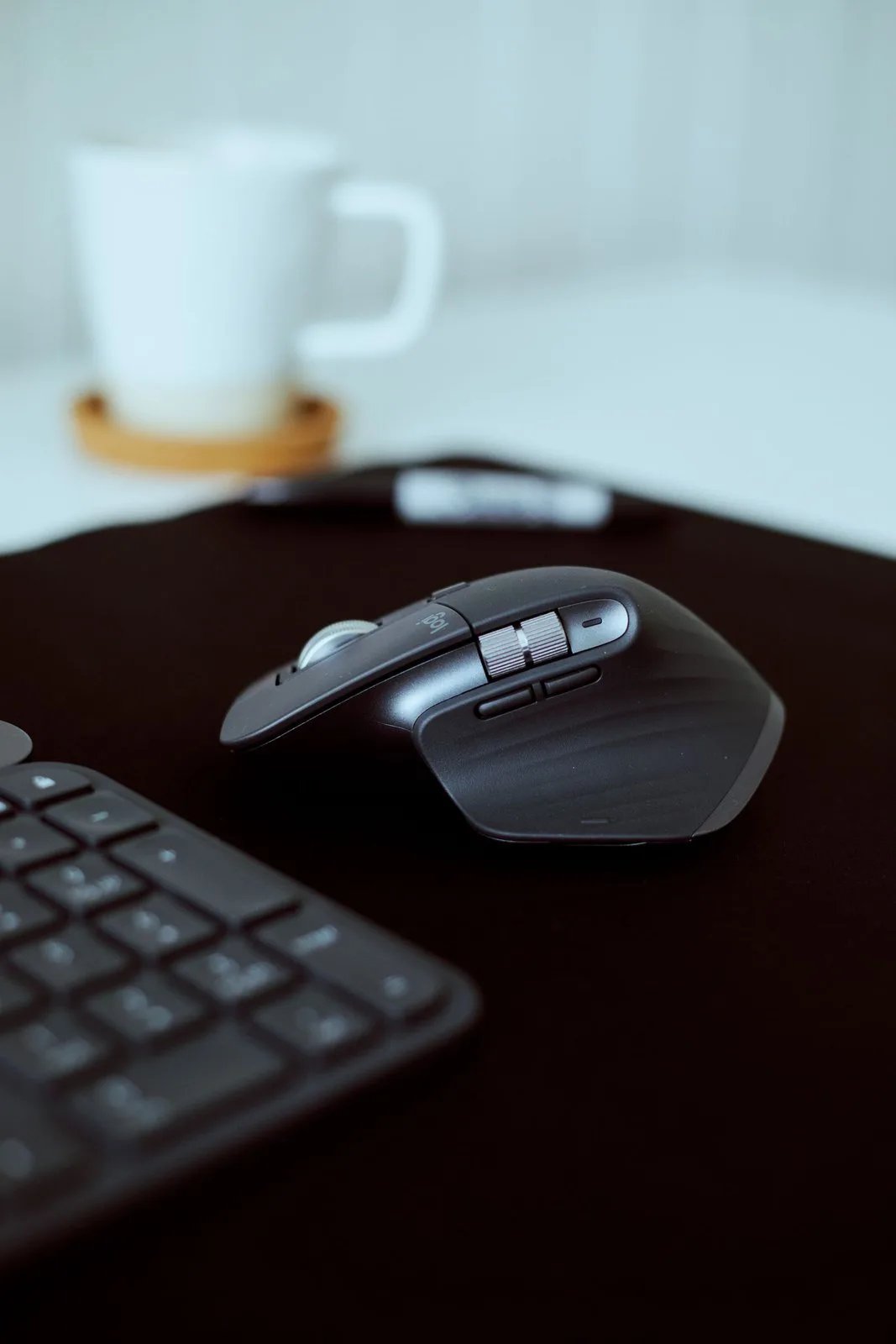Ergonomic wireless mouse beside a keyboard