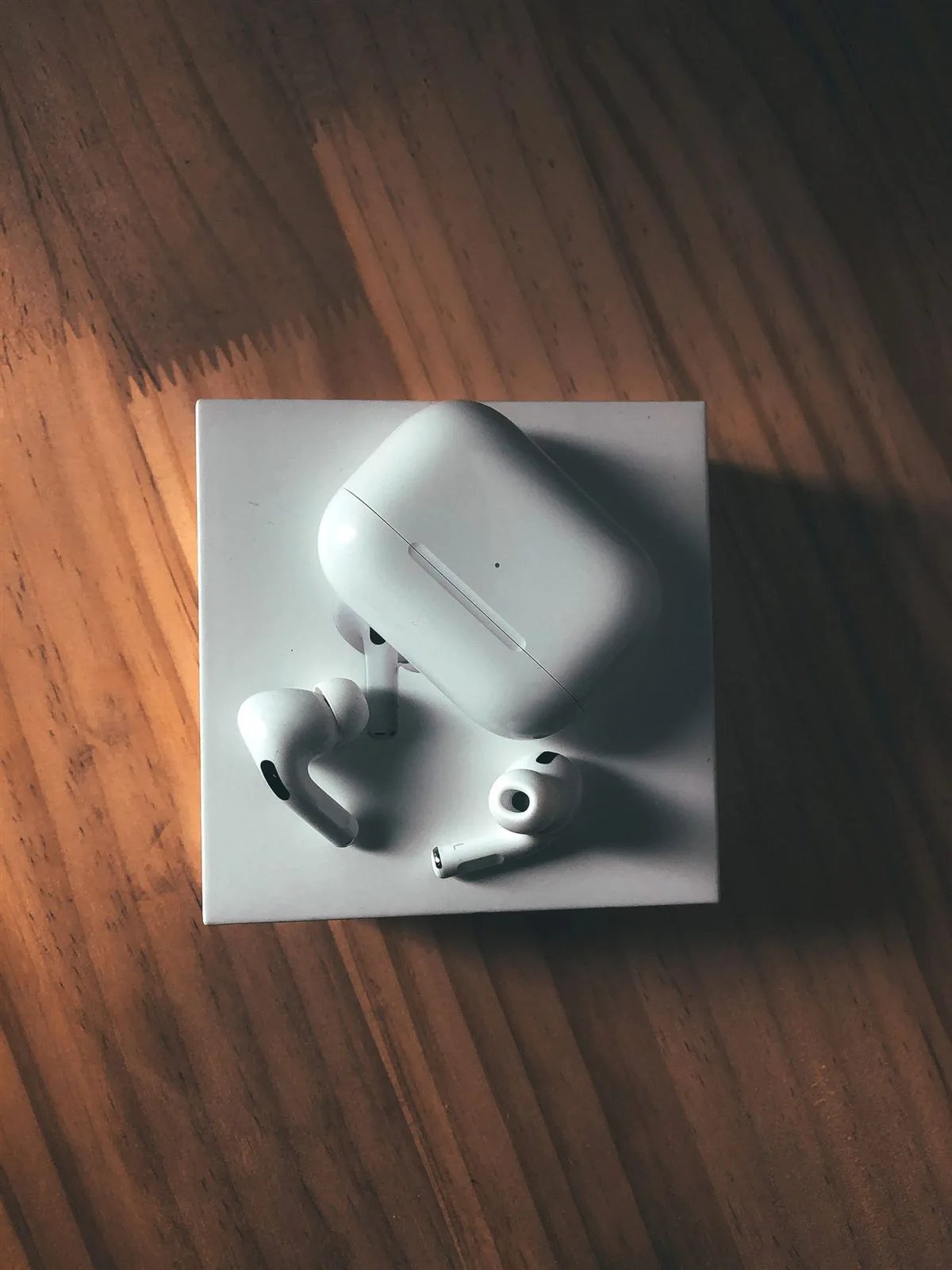 Earbuds Pro X with charging box on a wooden table